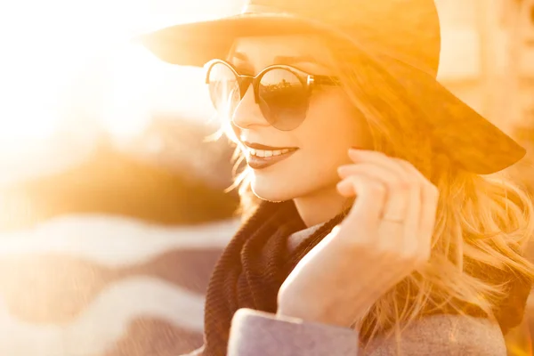 Κομψό όμορφη ξανθιά κοπέλα μια ηλιόλουστη μέρα σε ένα κομψό μαύρο καπέλο — Φωτογραφία Αρχείου