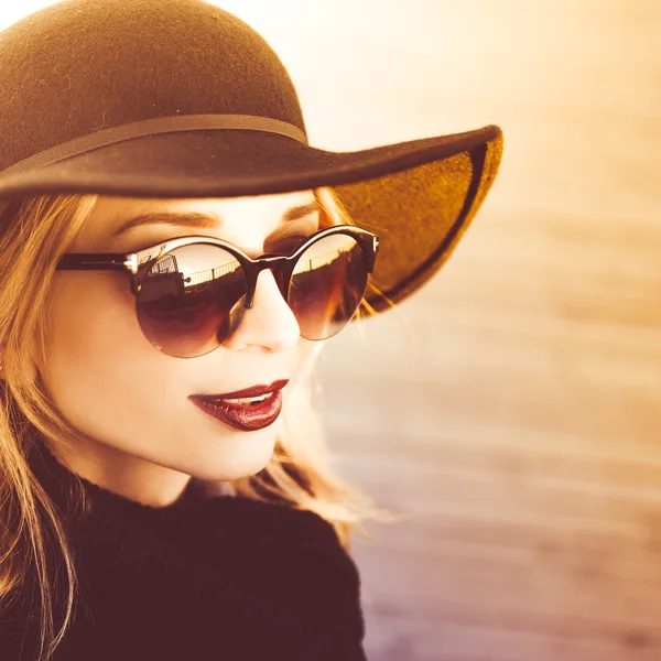 Menina loira bonita nova elegante em um dia ensolarado em um chapéu preto elegante — Fotografia de Stock