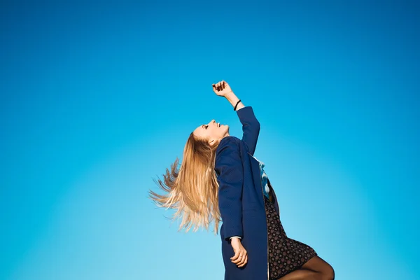 Jovem menina bonita em um fundo de céu azul — Fotografia de Stock