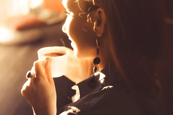 Schöne junge Mädchen bei Sonnenuntergang mit glatten blonden Haaren, die Kaffee trinken — Stockfoto