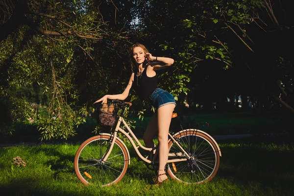 Mooie blonde vrouw met fiets — Stockfoto