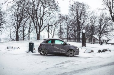 Tonsberg, Norveç - 13 Ocak 2021: gümüş Fiat 500 yeni elektrikli otomobil. Gece şarj istasyonunda yeni bir araba.