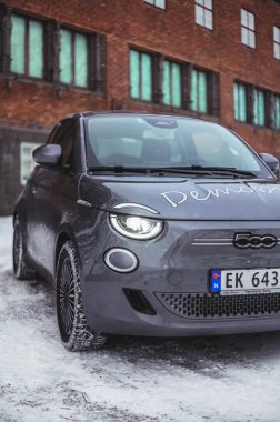 Tonsberg, Norveç - 13 Ocak 2021: gümüş Fiat 500 yeni elektrikli otomobil. Gece şarj istasyonunda yeni bir araba.