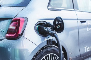 Tonsberg, Norveç - 13 Ocak 2021: gümüş Fiat 500 yeni elektrikli otomobil. Gece şarj istasyonunda yeni bir araba.