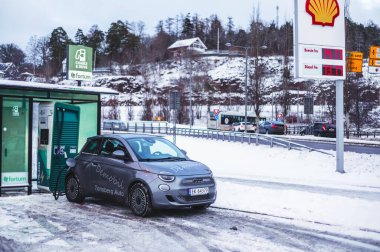 Tonsberg, Norveç - 13 Ocak 2021: gümüş Fiat 500 yeni elektrikli otomobil. Gece şarj istasyonunda yeni bir araba.