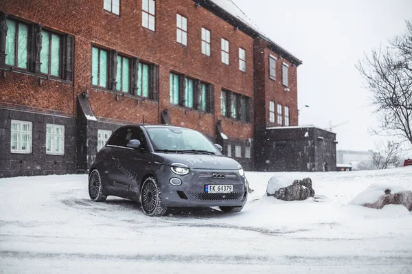 Tonsberg, Norveç - 13 Ocak 2021: gümüş Fiat 500 yeni elektrikli otomobil. Gece şarj istasyonunda yeni bir araba.