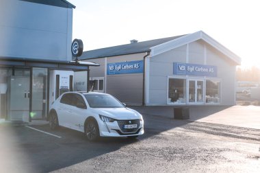 Tnsberg, Norveç - 23 Ocak 2021: inci beyazı elektrikli otomobil Peugeot e-208 GT yeni bir kompakt elektrikli otomobil. Şarj istasyonunda yeni bir araba