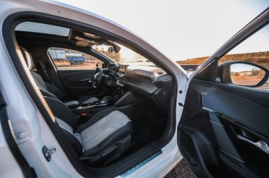 Tnsberg, Norveç - 23 Ocak 2021: inci beyazı elektrikli otomobil Peugeot e-208 GT yeni bir kompakt elektrikli otomobil. Şarj istasyonunda yeni bir araba