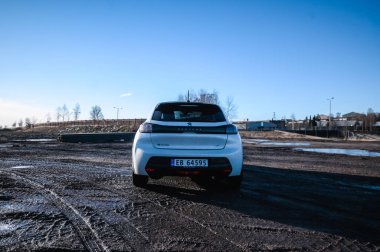 Tnsberg, Norveç - 23 Ocak 2021: inci beyazı elektrikli otomobil Peugeot e-208 GT yeni bir kompakt elektrikli otomobil. Şarj istasyonunda yeni bir araba