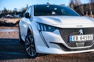 Tnsberg, Norveç - 23 Ocak 2021: inci beyazı elektrikli otomobil Peugeot e-208 GT yeni bir kompakt elektrikli otomobil. Şarj istasyonunda yeni bir araba