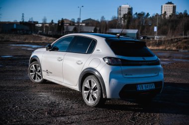 Tnsberg, Norveç - 23 Ocak 2021: inci beyazı elektrikli otomobil Peugeot e-208 GT yeni bir kompakt elektrikli otomobil. Şarj istasyonunda yeni bir araba