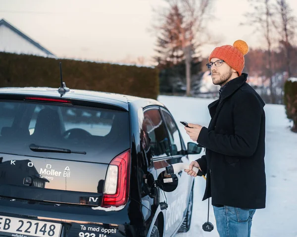 ノルウェーのTnsberg 2021年2月9日 黒シュコダ シティゴーIvは小型電気自動車です 晴れた冬の日の新車とオタクの男が車を充電している — ストック写真
