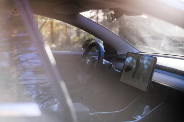 Tonsberg, Norveç - 18 Mart 2021: siyah Tesla modeli 3 Long Range çift motorlu arka planda İskandinav ormanı olan elektrikli bir otomobil..