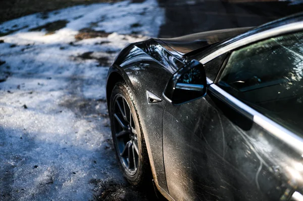 Tonsberg, Norveç - 18 Mart 2021: siyah Tesla modeli 3 Long Range çift motorlu arka planda İskandinav ormanı olan elektrikli bir otomobil..