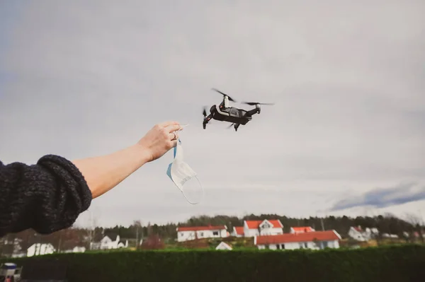 Nerdy guy using  drone for delivery while wearing face mask to avoid corona virus spreading - Technology and industrial concept