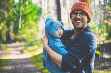 Ormanda bir bebekle yürüyen gözlüklü çekici inek portresi. Mutlu babalar