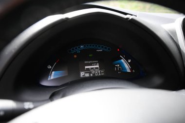 Tonsberg, Norveç - Nisan 06, 2021: Gri gri NISSAN LEAF, C segment elektrikli otomobil. Ormanda güneşli bir günde yeni bir araba.