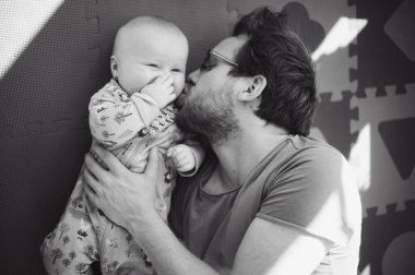 Evde gözlüklü, oğluyla oynayan çekici bir ineğin portresi. Sevimli erkek bebek. Mutlu babalar