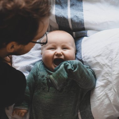 Evde gözlüklü, oğluyla oynayan ve öpüşen çekici bir inek portresi. Sevimli erkek bebek. Mutlu babalar