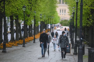 Oslo, Norveç - 15 Mayıs 2021: Covid-19 salgını sırasında başkent İskandinavya 'nın sokaklarındaki insanlar. Maske takan insanlar.