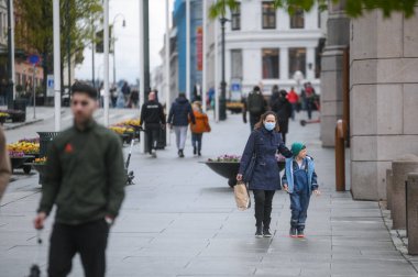 Oslo, Norveç - 15 Mayıs 2021: Covid-19 salgını sırasında başkent İskandinavya 'nın sokaklarındaki insanlar. Maske takan insanlar.
