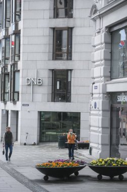 Oslo, Norveç - 15 Mayıs 2021: Covid-19 salgını sırasında başkent İskandinavya 'nın sokaklarındaki insanlar. Maske takan insanlar.