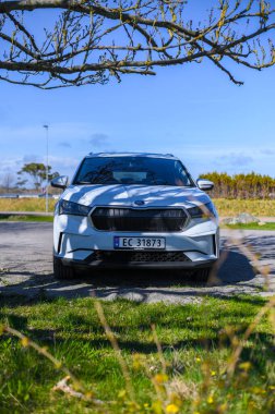 Tonsberg, Norveç - 15 Mayıs 2021: Beyaz Skoda enyaq IV bir SUV elektrikli arabadır. Kırsalda yeni bir araba.
