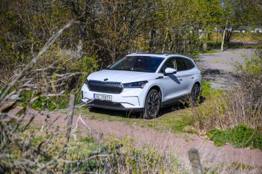 Tonsberg, Norveç - 15 Mayıs 2021: Beyaz Skoda enyaq IV bir SUV elektrikli arabadır. Kırsalda yeni bir araba.