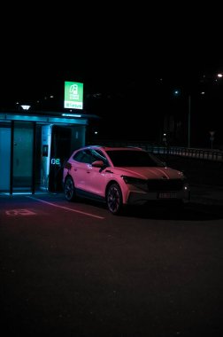 Tonsberg, Norveç - 15 Mayıs 2021: Beyaz Skoda enyaq IV bir SUV elektrikli arabadır. Gece şarj istasyonunda yeni bir araba.