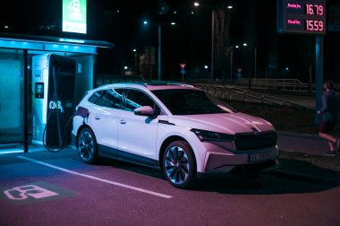 Tonsberg, Norveç - 15 Mayıs 2021: Beyaz Skoda enyaq IV bir SUV elektrikli arabadır. Gece şarj istasyonunda yeni bir araba.