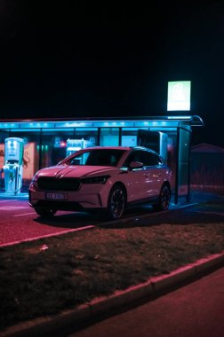 Tonsberg, Norveç - 15 Mayıs 2021: Beyaz Skoda enyaq IV bir SUV elektrikli arabadır. Gece şarj istasyonunda yeni bir araba.