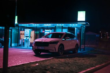 Tonsberg, Norveç - 15 Mayıs 2021: Beyaz Skoda enyaq IV bir SUV elektrikli arabadır. Gece şarj istasyonunda yeni bir araba.