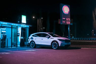 Tonsberg, Norveç - 15 Mayıs 2021: Beyaz Skoda enyaq IV bir SUV elektrikli arabadır. Gece şarj istasyonunda yeni bir araba.