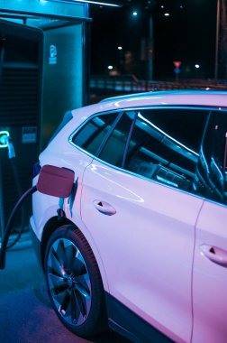 Tonsberg, Norveç - 15 Mayıs 2021: Beyaz Skoda enyaq IV bir SUV elektrikli arabadır. Gece şarj istasyonunda yeni bir araba.