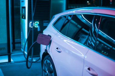 Tonsberg, Norveç - 15 Mayıs 2021: Beyaz Skoda enyaq IV bir SUV elektrikli arabadır. Gece şarj istasyonunda yeni bir araba.