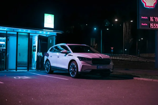 Tonsberg, Norveç - 15 Mayıs 2021: Beyaz Skoda enyaq IV bir SUV elektrikli arabadır. Gece şarj istasyonunda yeni bir araba.