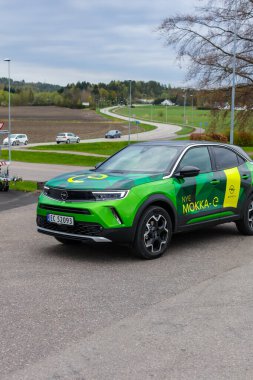 Tonsberg, Norveç - 4 Mayıs 2021: Green Opel Mokka-e elektrikli otomobil. Gece şarj istasyonunda yeni bir araba.