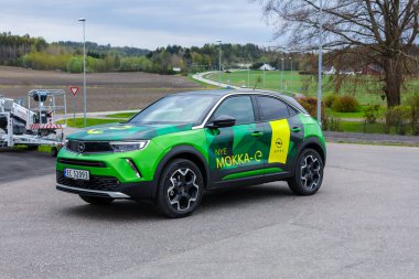 Tonsberg, Norveç - 4 Mayıs 2021: Green Opel Mokka-e elektrikli otomobil. Gece şarj istasyonunda yeni bir araba.