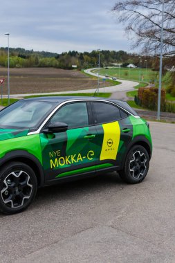 Tonsberg, Norveç - 4 Mayıs 2021: Green Opel Mokka-e elektrikli otomobil. Gece şarj istasyonunda yeni bir araba.