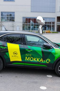 Tonsberg, Norveç - 4 Mayıs 2021: Green Opel Mokka-e elektrikli otomobil. Gece şarj istasyonunda yeni bir araba.