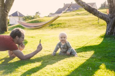 Parktaki gözlüklü çekici ineğin portresi hamağın yanında bir çocukla güzel bir gün geçir. Mutlu babalar