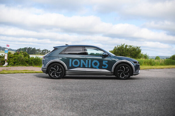 Тонсберг, Норвегия - 4 июля 2021 года: синий серый электрокар Hyundai Ioniq рядом с водой