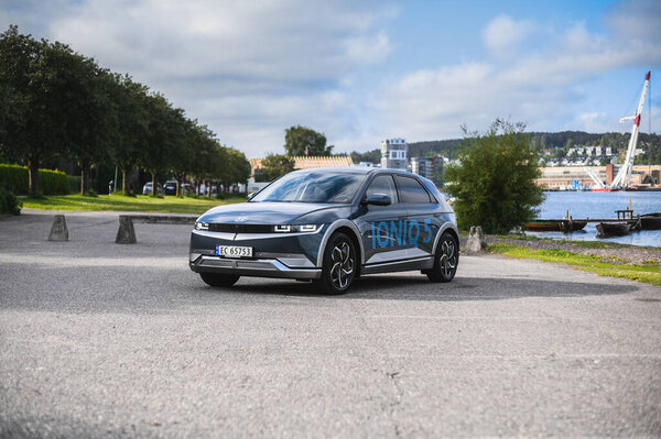 Тонсберг, Норвегия - 4 июля 2021 года: синий серый электрокар Hyundai Ioniq рядом с водой