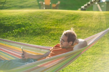 Parktaki yeşil çimenli gözlüklü çekici inek portresinin hamakta güzel bir günbatımı var. Telefonla iyi oyalanmalar.
