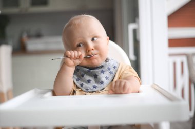 Bebek maması yerken gülümseyen sevimli bir çocuğun portresi. Mutlu çocukluk