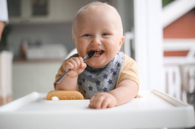 Bebek maması yerken gülümseyen sevimli bir çocuğun portresi. Mutlu çocukluk