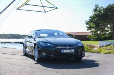 Notteroy, Norveç - 22 Ağustos 2021 Tesla model S P85 + arka planda İskandinav limanı olan elektrikli bir otomobil..