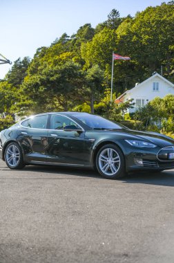 Notteroy, Norveç - 22 Ağustos 2021 Tesla model S P85 + arka planda İskandinav limanı olan elektrikli bir otomobil..