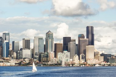 View of Seattle skyline and waterfront with yacht. Bright, sunny day with clouds. clipart