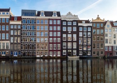 Amsterdam, Hollanda 16 Aralık 2020: Güneşli bir kış gününde Damrak Kanalı 'ndaki eski Amsterdam depoları
